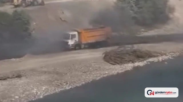 Alev alan hafriyat kamyonu sürücüsü aracı dereye sürdü